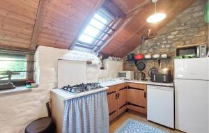 a kitchen with a stove and a refrigerator at 2 Bedroom Nice Home In Le Ferré in Le Ferré