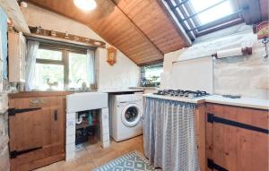 a kitchen with a stove and a washing machine at 2 Bedroom Nice Home In Le Ferré in Le Ferré