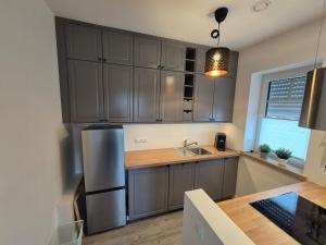 a kitchen with gray cabinets and a stainless steel refrigerator at Gemütliche Einliegerwohnung in Drantum