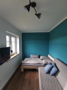 a bedroom with blue walls and a bed and a window at Gemütliche Einliegerwohnung in Drantum