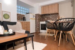 a kitchen and living room with a table and chairs at Dione Central Loft in Heraklio Town