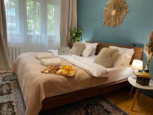 1 cama con bandeja de fruta y ordenador portátil. en LaLa House Botanica, en Chişinău