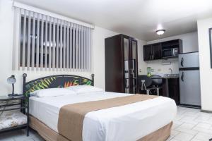 a bedroom with a large bed and a kitchen at Oro Apart Hotel in San Antonio