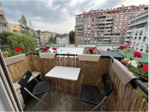 Un balcón con una mesa y sillas en un balcón. en Relax apartman bg, en Belgrado