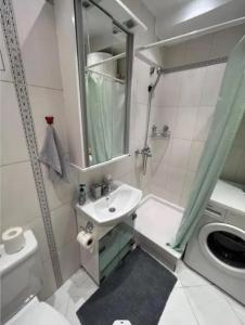 Un baño con lavabo, inodoro y ducha. en Relax apartman bg, en Belgrado