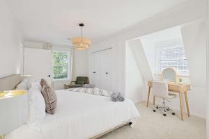 una camera da letto bianca con un letto e una scrivania di Luxurious 6BR 3BA Villa with Hot Tub a Sherman