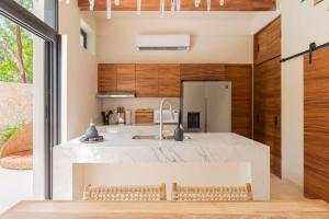 een keuken met een groot wit aanrecht en houten kasten bij 3BR Villa in Tulum, Pool plus Concierge in Tulum +34 foto's