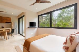 een slaapkamer met een bed en een groot raam bij 3BR Villa in Tulum, Pool plus Concierge in Tulum