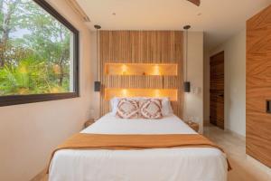 een slaapkamer met een groot bed en een raam bij 3BR Villa in Tulum, Pool plus Concierge in Tulum