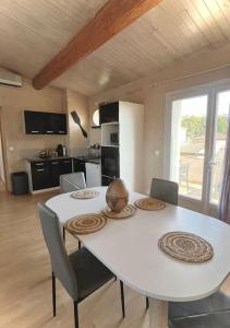 Appartement de 2 à 6 personnes 3 chambres proche Aéroport Marseille Marignane -confortable - et tout équipé في روجناك: طاولة طعام بيضاء مع كراسي ومطبخ