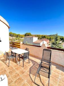 Appartement de 2 à 6 personnes 3 chambres proche Aéroport Marseille Marignane -confortable - et tout équipé في روجناك: فناء مع طاولة وكراسي على شرفة +18 صورة