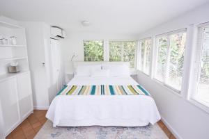 - une chambre blanche avec un lit et des fenêtres dans l'établissement Miami Pool Cottage, tropical garden paradise, à Miami 39 autres photos