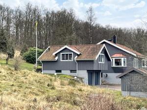 a black and white house on a hill at 4 star holiday home in Romelanda in Romelanda