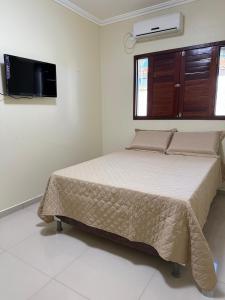 ピラーニャスにあるCasa por temporada águas do Velho Chicoのベッドと薄型テレビのある寝室