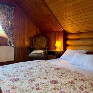 a bedroom with a large bed and a chair at Cottage Kalinka in Bukovel +97 photos