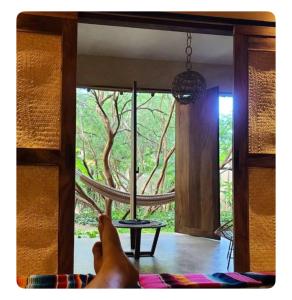 a person laying on a bed looking out of a window at Casa Huizache I in Malucano +1 photo