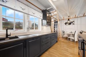 a kitchen with a sink and a window and a table at Tjeldsund Rorbu in Steinsland