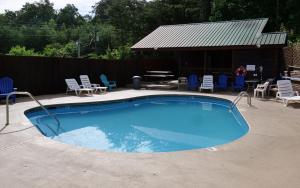 a large swimming pool with chairs and a table at Bear Retreat in Pigeon Forge
