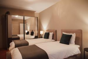 a hotel room with two beds and a mirror at Apartment Rhea with Terrace & Parking in Plovdiv