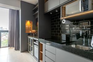 a kitchen with a sink and a microwave at Studio Style - Vila Olímpia in Sao Paulo