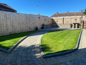 a backyard with a fence and green grass at Bushmills holiday home in Bushmills