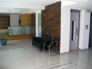 een lobby met 2 stoelen en een bakstenen muur bij Bay View Apartments in Albufeira +110 foto's