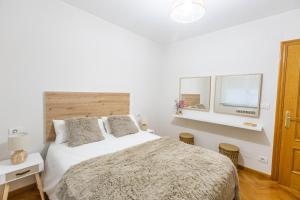 a white bedroom with a bed and two windows at Apartamento Ronda Muralla in Lugo +23 photos