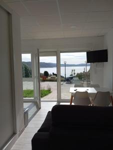 Una sala de estar con un sofá y una mesa con sillas. en Apartamentos NEMIÑA, en A Coruña