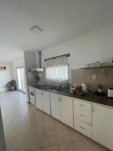 a kitchen with white cabinets and a black counter top at Amplia Casa - Vista Verde in Villa María