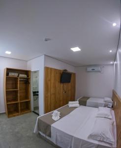 a bedroom with a large bed and a television at Pousada Recanto Dourado in Bonito