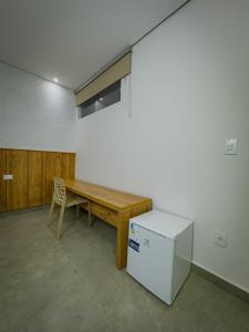 a room with a wooden table and a refrigerator at Pousada Recanto Dourado in Bonito