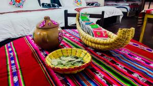 a table with two baskets and a tea pot on a bed at Utasa del Titicaca in Puno