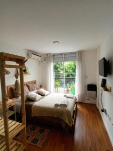 a bedroom with a bed and a large window at Mono Ov Lagos in Rosario