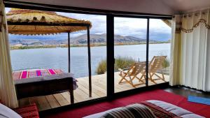 a room with a balcony with a view of the water at Utasa del Titicaca in Puno +27 photos