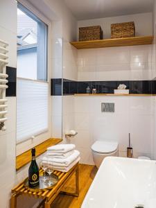 ein Badezimmer mit einem WC und einem Tisch mit Weingläsern in der Unterkunft Swebenhus unnern - Appartement mit Charme in Plau am See