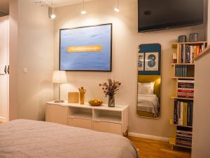 ein Schlafzimmer mit einem Bett, einem Schreibtisch und einem Spiegel in der Unterkunft Swebenhus unnern - Appartement mit Charme in Plau am See