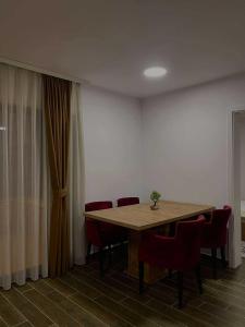 a dining room with a table and red chairs at Umbrella Resort & Villas in Prishtinë
