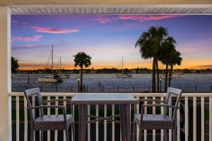 Una mesa y sillas en un balcón con vista al agua. en Best Western Historic Bayfront, en St. Augustine