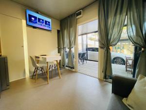 a living room with a desk and a tv on the wall at Žaba-Kamp Dalmacija in Privlaka