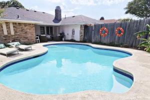 a swimming pool in a backyard with a wooden fence at City Gem 4BR with POOL Sleeps 8 in Plano