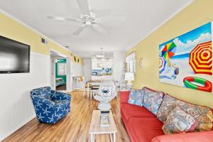 a living room with a red couch and a tv at Sea Cabin 147 - 2nd Row - Cherry Grove Section in Myrtle Beach
