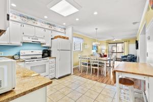 a kitchen with white appliances and a dining room at Sea Cabin 147 - 2nd Row - Cherry Grove Section in Myrtle Beach