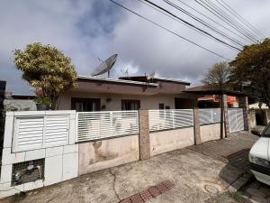 a house with a white fence in front of it at Bombinhas, Casa, 3 quartos, c piscina em Bombas - SC in Bombinhas