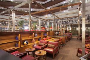 a restaurant with tables and chairs in a room at Sandton Sun and Towers in Johannesburg