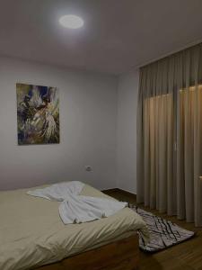 a bedroom with a bed with a painting on the wall at Umbrella Resort & Villas in Prishtinë +40 photos