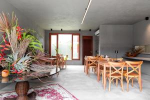 a dining room with wooden tables and chairs at Pousada Oribá Chalé Boutique Milagres - AL in São Miguel dos Milagres