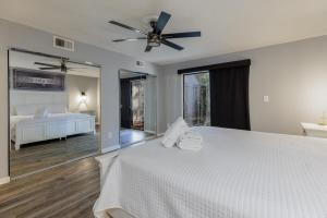 a bedroom with a white bed with a ceiling fan at 573 Queen's Grant in Coffeyville +25 photos