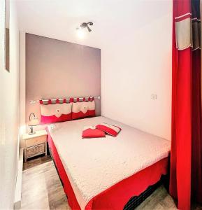 małą sypialnię z czerwono-białym łóżkiem w obiekcie Résidence Zodiaque - BEAU STUDIO ALCOVE DE 31M² MAE-6794 w mieście Villarembert