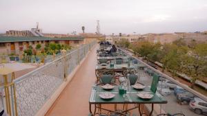 a balcony with tables and chairs on a building at Riad Golden Mansour in Meknès