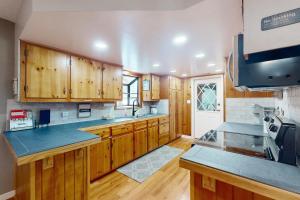 cocina grande con armarios de madera y encimeras azules en Uhre Family Retreat, en Oakhurst